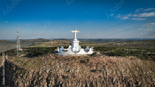 Statue of Christ stands majestically on a hillside in Lubango, Angola, overlooking the landscape during daylight photo