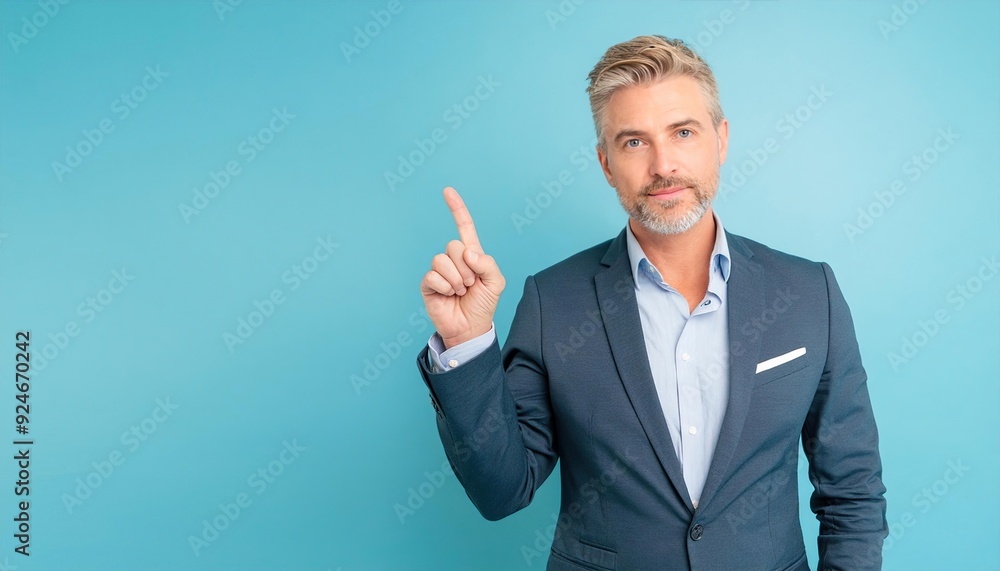 Middle-aged businessman pointing finger isolated on light blue background with copy space Middle-aged businessman pointing finger isolated on light blue background with copy space
