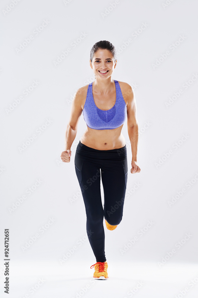 Happy woman, portrait and running with fitness for exercise, workout or cardio training on a studio background. Active female person or young runner with smile for health and wellness on mockup space Happy woman, portrait and running with fitness for exercise, workout or cardio training on a studio background. Active female person or young runner with smile for health and wellness on mockup space