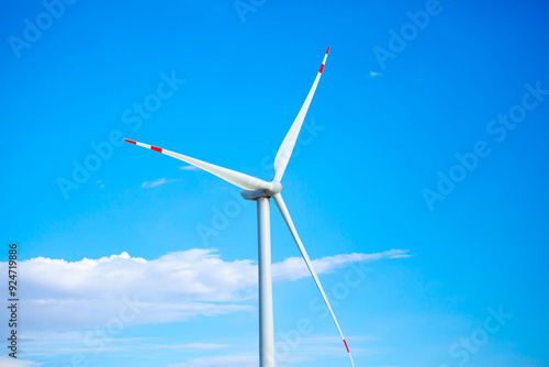 Fleet of power generators in motion. The blades of the wind farm rotate against the sky. The concept of extracting electricity from renewable sources. Wind turbine to generate electricity.