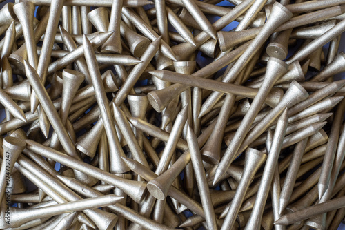 A large pile of Gold colour Wooden Golf Tees in a box