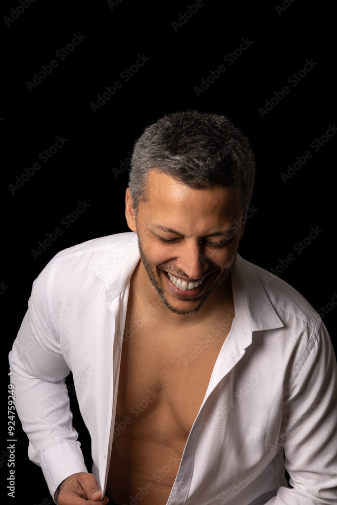 Fototapeta premium A man in a white shirt is smiling and showing off his chest