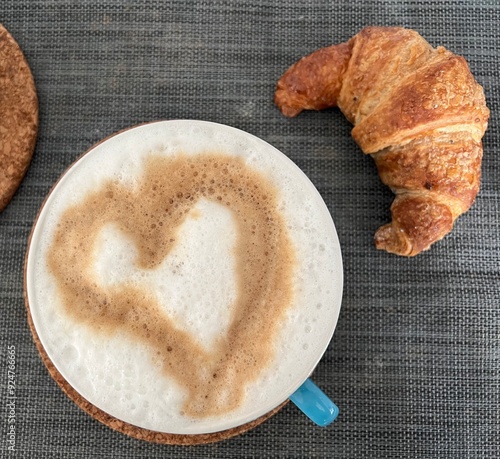 primo piano di colazione con cappuccino e cornetto photo