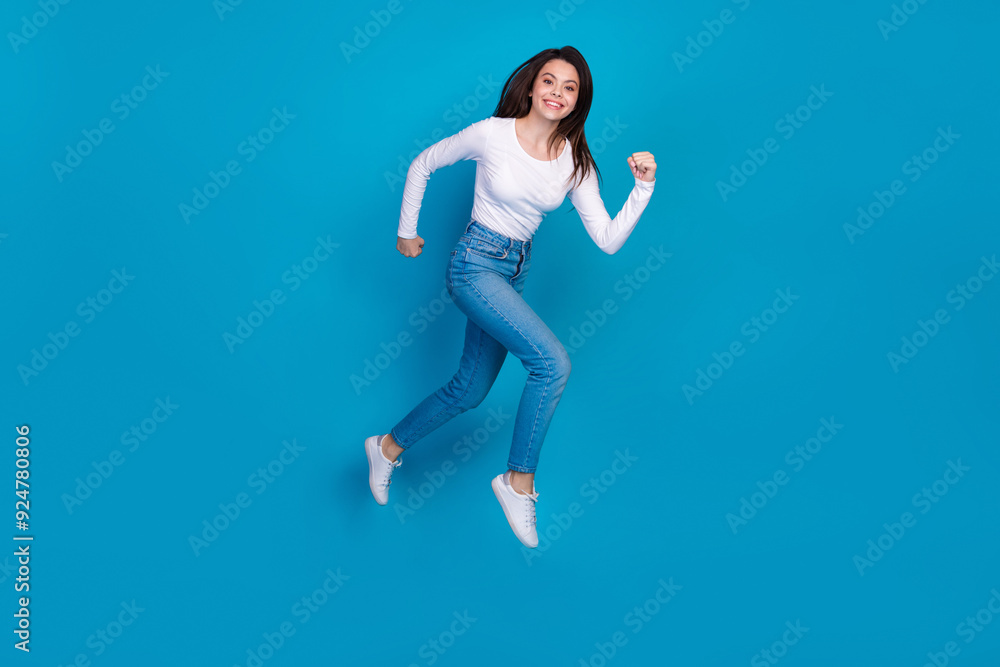 Full length photo of lovely teen lady running fast have fun dressed stylish white garment isolated on blue color background Full length photo of lovely teen lady running fast have fun dressed stylish white garment isolated on blue color background