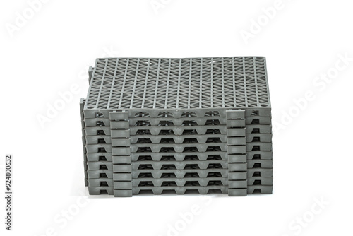 Stack of Anti-slip rubber mats in the bathroom, isolated on white background panels have a grid-like pattern on their surface, providing a sturdy and slip-resistant surface panels are stacked neatly