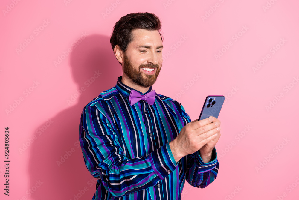 Photo of handsome elegant man wear stylish clothes use gadget isolated on pink color background Photo of handsome elegant man wear stylish clothes use gadget isolated on pink color background