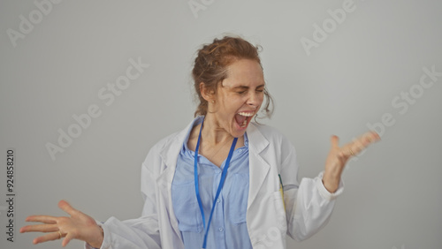 A young caucasian female doctor in a lab coat showing frustration against a white background photo