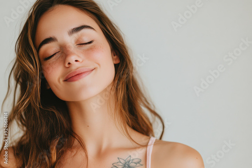 A close up of a woman's face with tattoos and her eyes closed