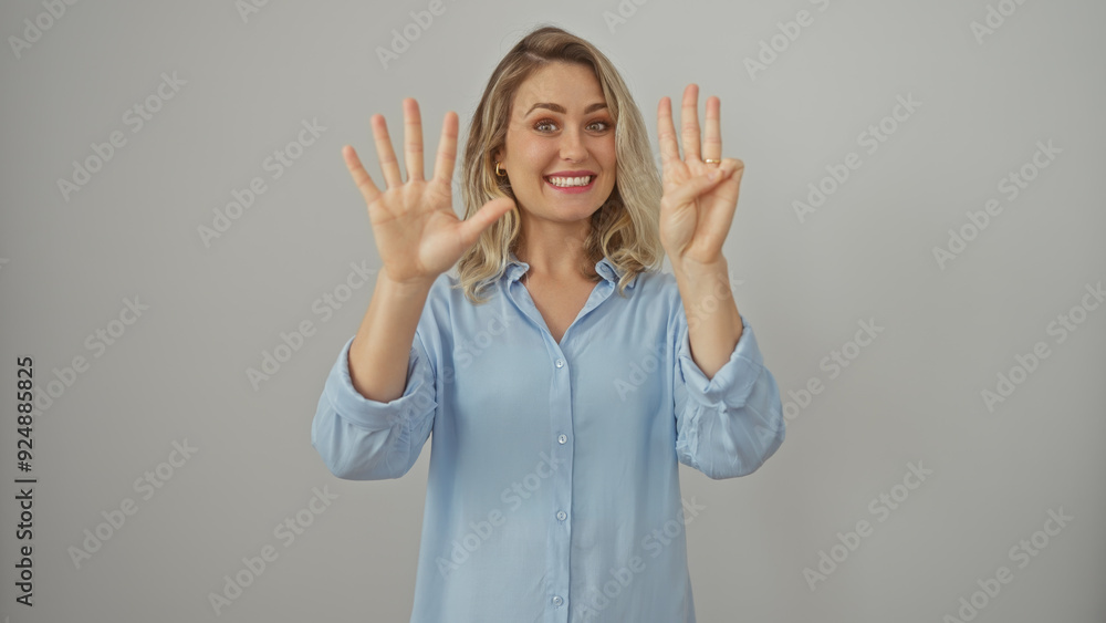Smiling blonde woman in blue shirt gesturing eight with her hands on a white background. Smiling blonde woman in blue shirt gesturing eight with her hands on a white background.