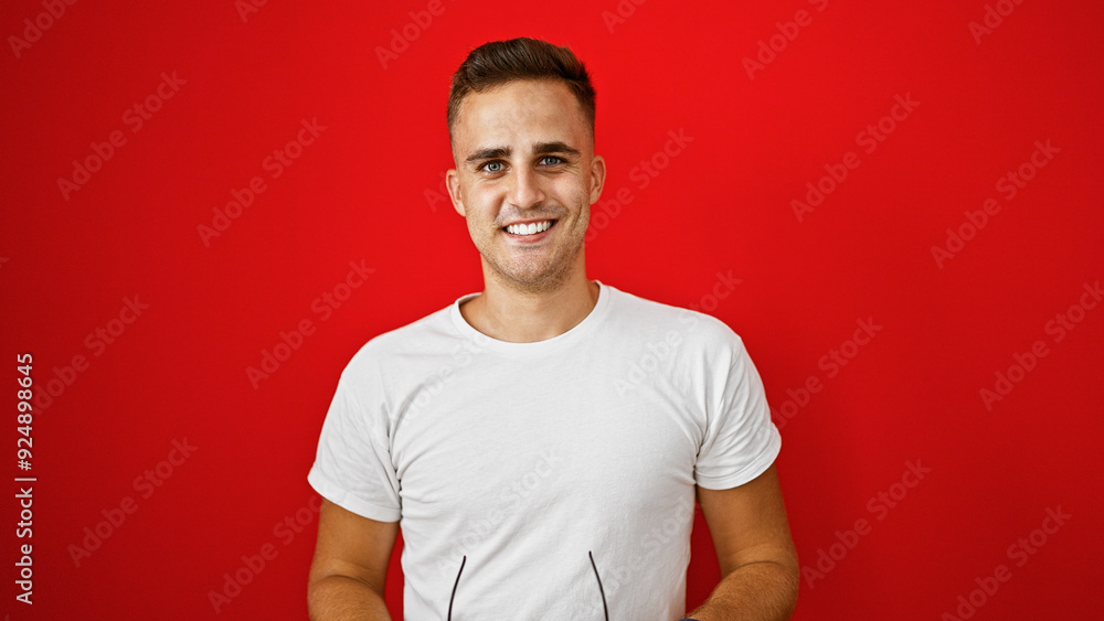 Young hispanic man smiling confidently against an isolated red background, portraying casual handsomeness. Young hispanic man smiling confidently against an isolated red background, portraying casual handsomeness.