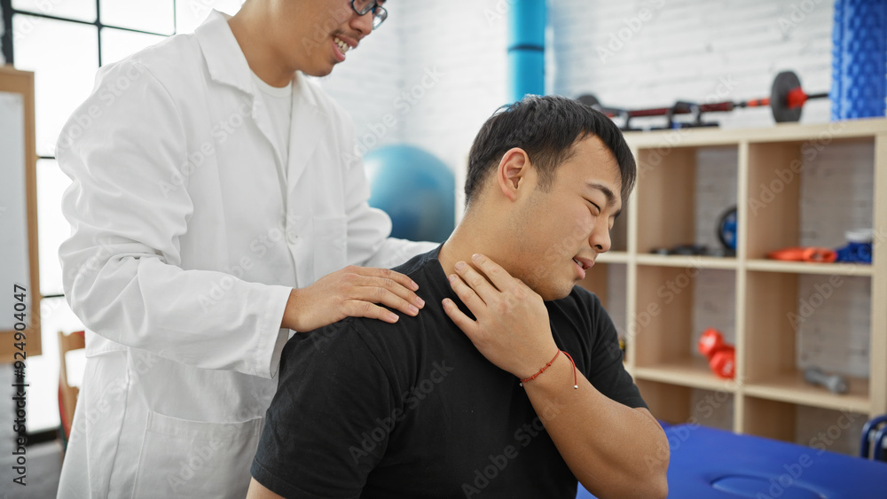 A male physiotherapist treats a male patient's neck pain in a clinic's therapy room A male physiotherapist treats a male patient's neck pain in a clinic's therapy room