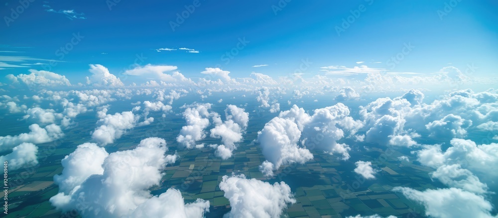 Naklejka premium An aerial photograph capturing the sky white clouds and expansive farmland below providing a serene copy space image