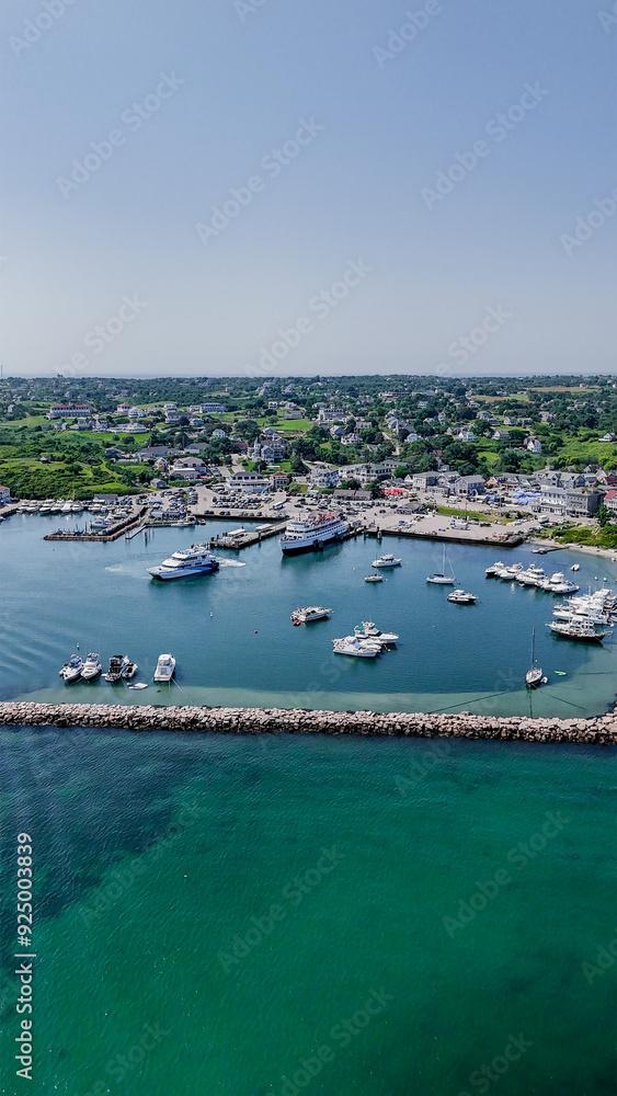 Fototapeta premium New Shoreham, RI, USA - August 5 2024: Vertical aerial image of Old Harbor, Block Island, New Shoreham, RI and local downtown area and ferry terminal. 