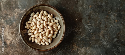 Top view of a plate with raw white beans on a table with a copy space image