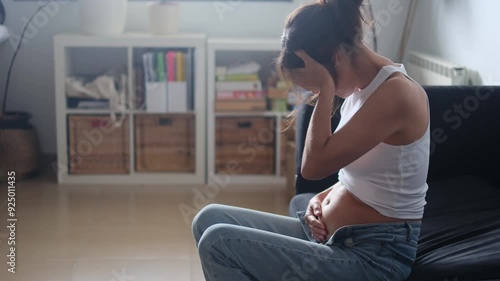 Pregnant woman feeling morning sickness and hormonal discomfort, holding her head in pain. Highlights first-trimester pregnancy symptoms and reproductive health challenges photo