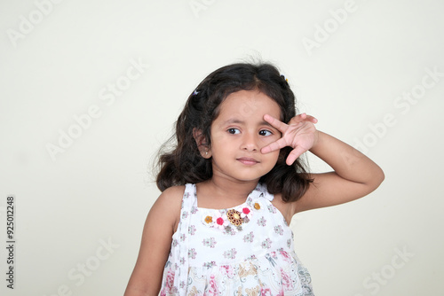  A delightful little girl with sparkling eyes, breaking into a wide, infectious smile. Her expression radiates pure happiness and innocence.