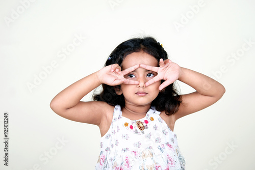  A delightful little girl with sparkling eyes, breaking into a wide, infectious smile. Her expression radiates pure happiness and innocence.