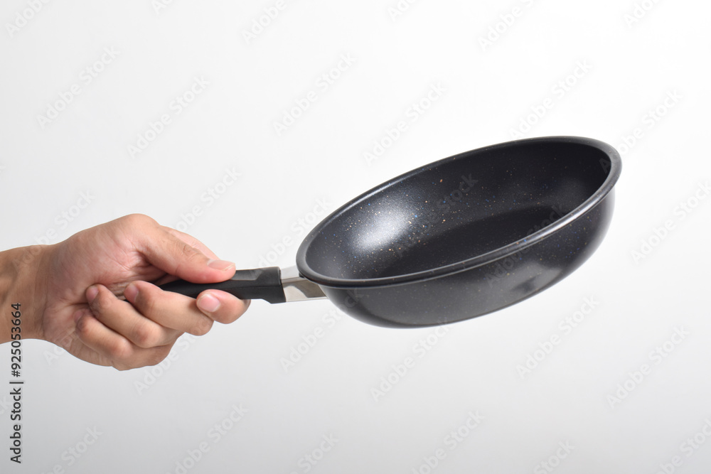 Hand holding Black frying pan with a non-stick coating isolated on white background Hand holding Black frying pan with a non-stick coating isolated on white background