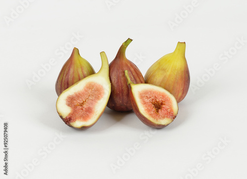 Close-up of two raw fig fruits with two half-cut ones on white floor, South Korea