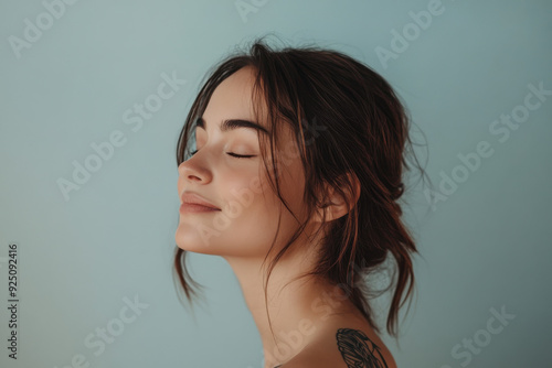 A close up of a woman's face with tattoos and her eyes closed