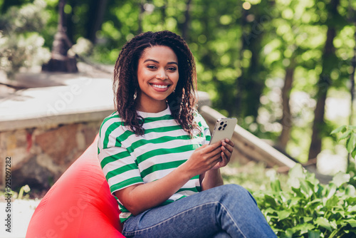 Portrait of nice young woman sit bag use phone pastime weekend chill fresh air park outdoors