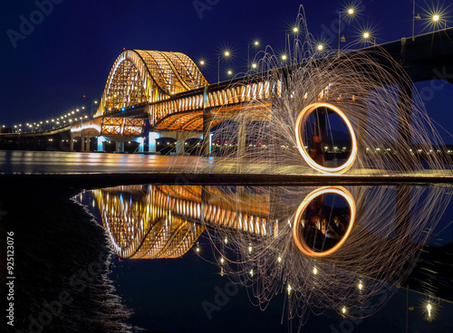 Yeongdeungpo-gu, Seoul, South Korea - June 27, 2015: Long exposure of Jwibulnori fire with water reflection against Banghwa Bridge on Han River with illumination photo