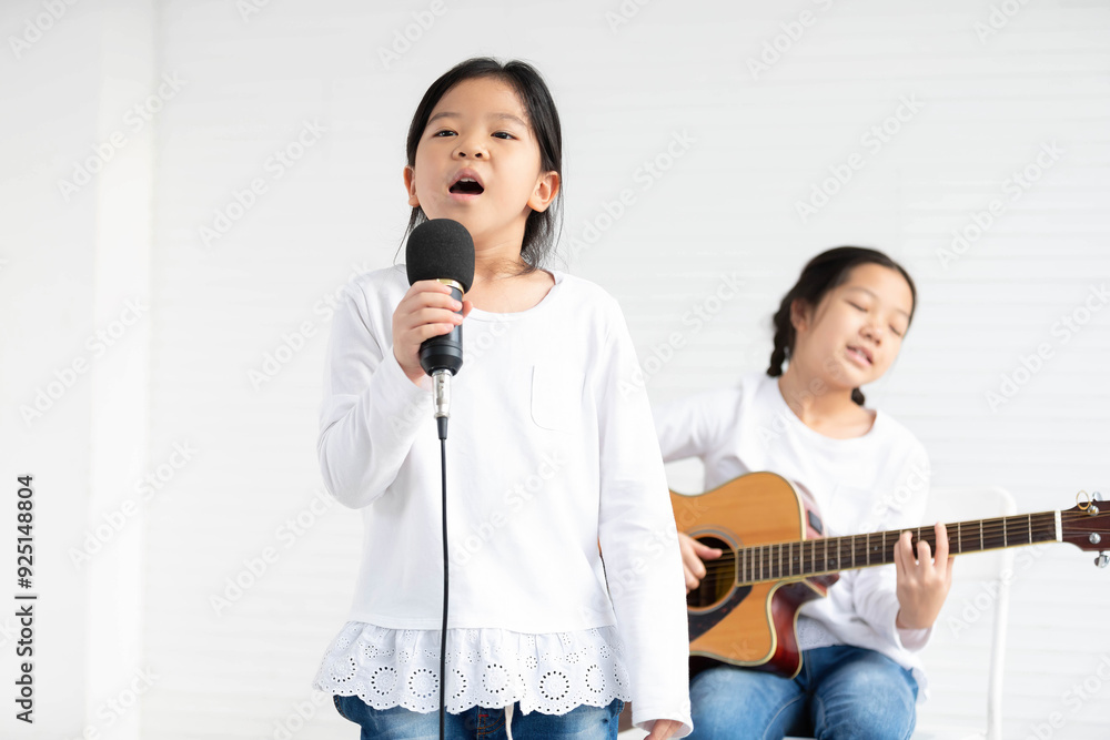 Girls singing song and playing guitar in the classroom Girls singing song and playing guitar in the classroom