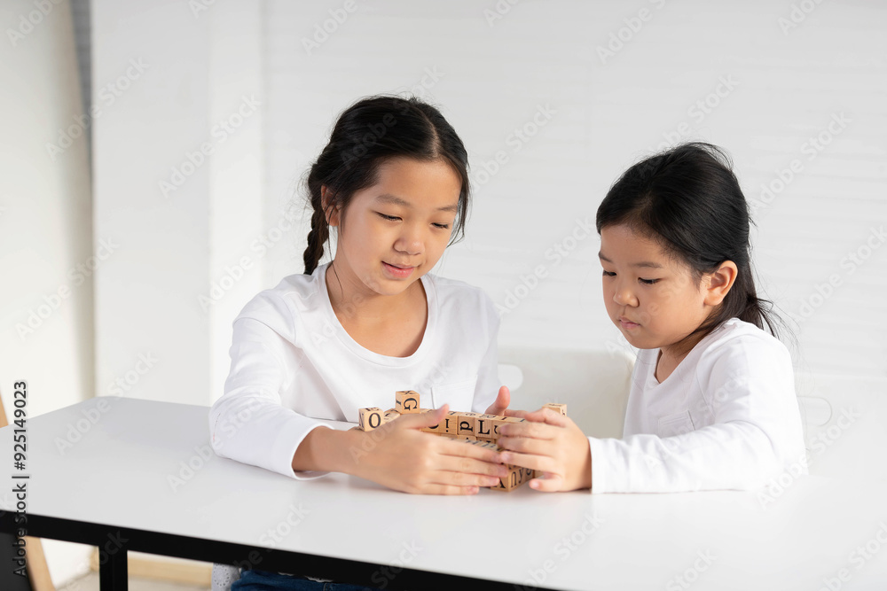 Girls playing wooden ABC toy building blocks on the table Girls playing wooden ABC toy building blocks on the table