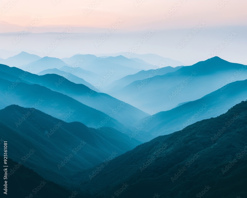 Obraz premium A majestic view of rolling blue mountains shrouded in mist, creating a tranquil and serene atmosphere.