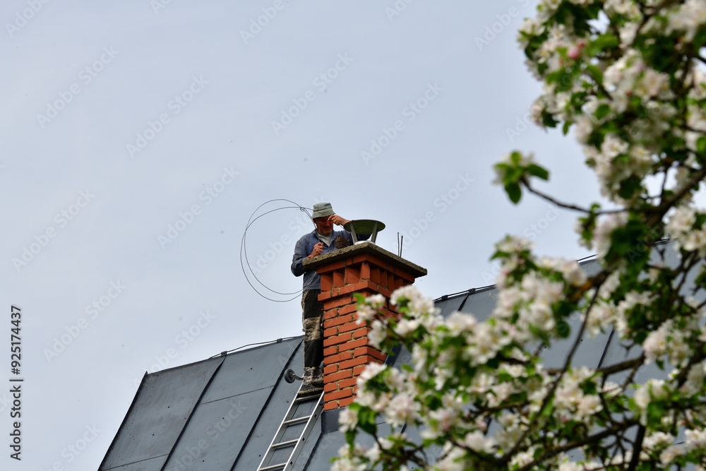 Traditional manual method of cleaning the chimney on the roof