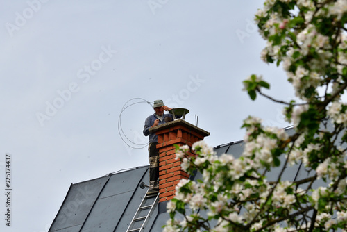 Obraz na płótnie Traditional manual method of cleaning the chimney on the roof w salonie