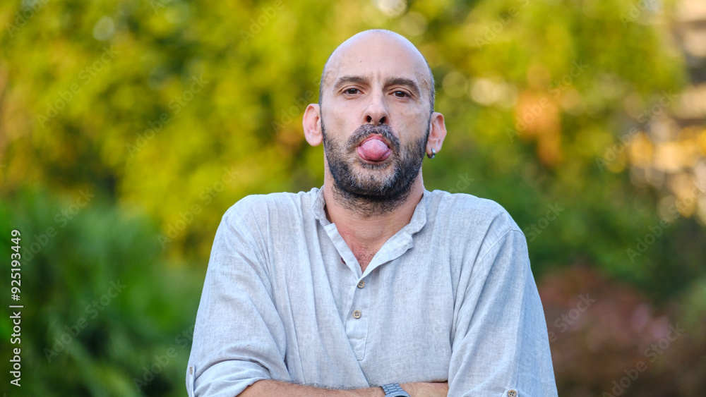 A middle-aged handsome businessman in a tree-lined park on a summer day, looking at the camera with enjoyment and making playful and funny facial expressions A middle-aged handsome businessman in a tree-lined park on a summer day, looking at the camera with enjoyment and making playful and funny facial expressions
