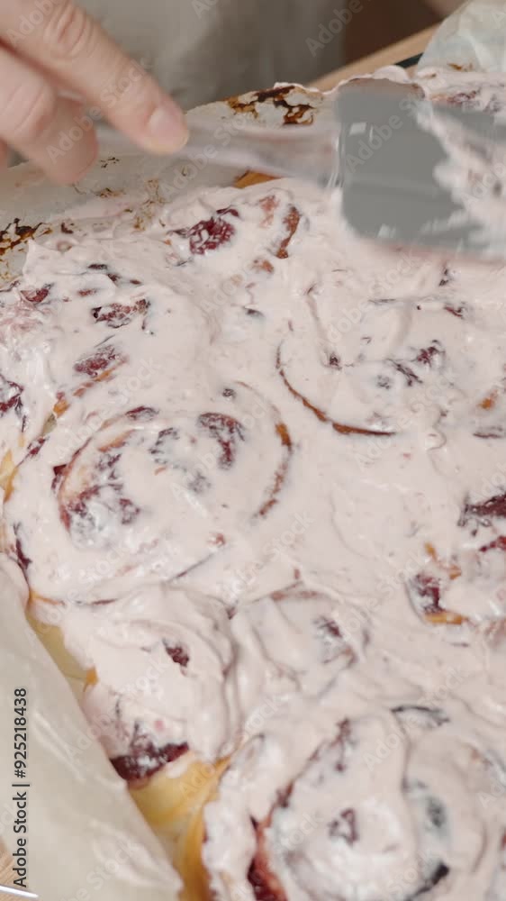 Vertical video. Covering Baked Rolls with a Generous Layer of Frosting, Ready to Serve. Vertical video. Covering Baked Rolls with a Generous Layer of Frosting, Ready to Serve.