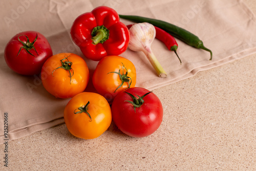 Fresh wet red and yellow tomatoes with peppers and garlic on a table