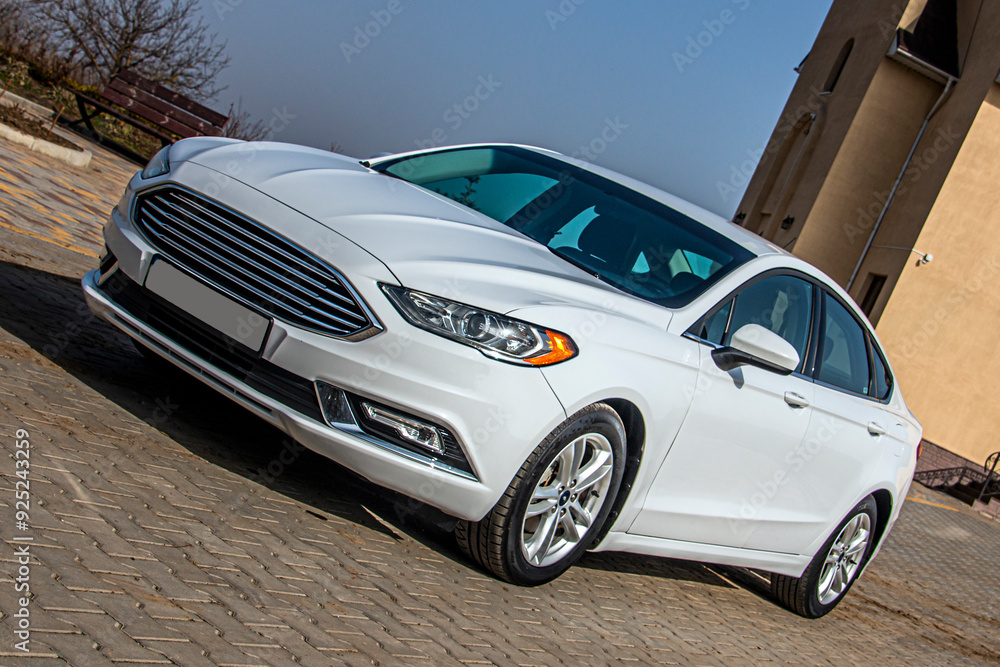 A beautiful white car stands on the paving stones during the day A beautiful white car stands on the paving stones during the day