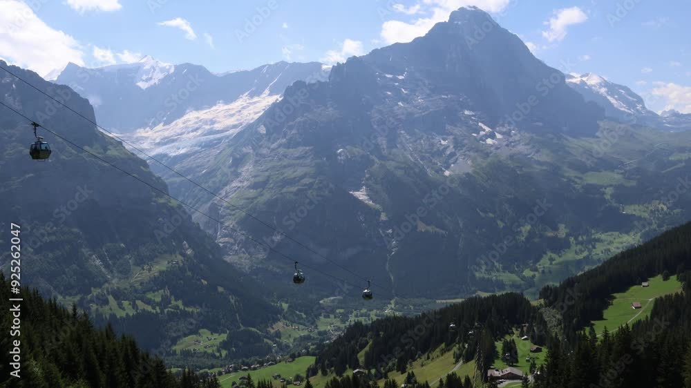 Cable cars ascending up the cable in Swiss alps, Grindelwald valley Cable cars ascending up the cable in Swiss alps, Grindelwald valley