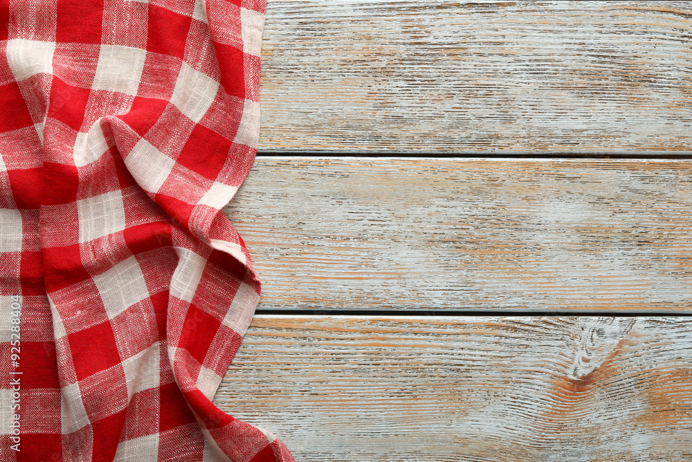 Red checkered picnic tablecloth on old wooden table, top view. Space for text Red checkered picnic tablecloth on old wooden table, top view. Space for text