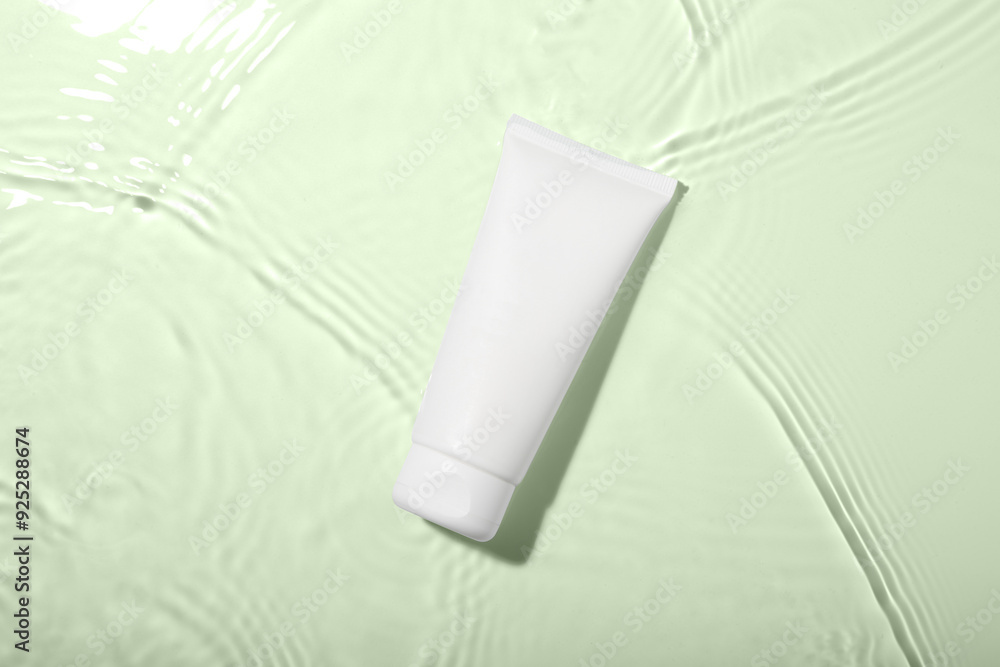 Cosmetic product. Tube with cream in water on light background, top view Cosmetic product. Tube with cream in water on light background, top view