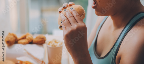 Binge eating disorder concept with woman eating fast food burger, fired chicken , donuts and desserts photo