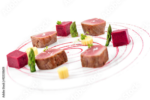 Red tuna steaks with asparagus and beet sauce on white background