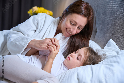 Mom wakes up her little daughter in the morning