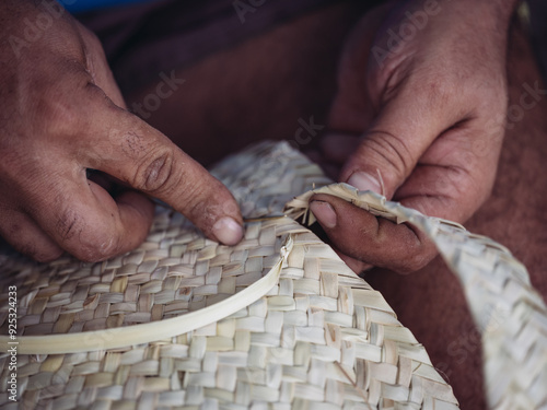 Canvastavla Close-up of hands skillfully weaving a palmito basket