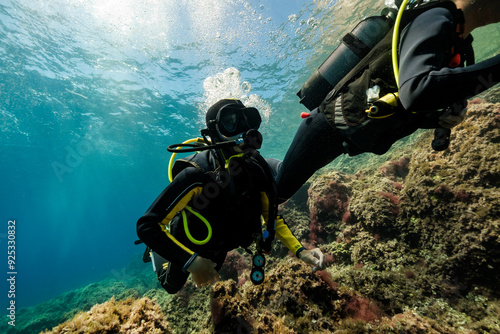 Wallpaper Mural Unrecognizable active divers in black wetsuit and masks scuba diving in deep ocean near coral reef while enjoying vacation at Menorca Torontodigital.ca