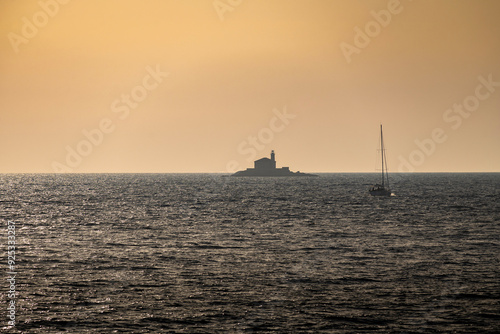 Stone lighthouse Mulo far on the horizon in front of small tourist town of Rogoznica, Croatia, on the open, Adriatic sea