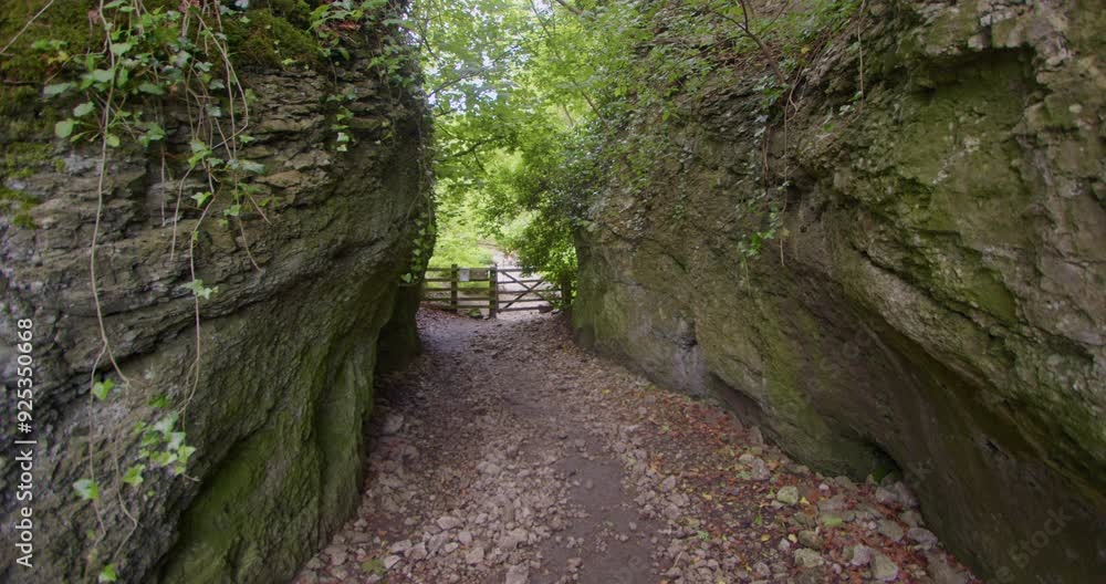 wide shot of the north end Gated entrance of cave Dale by large rocks at Castleton wide shot of the north end Gated entrance of cave Dale by large rocks at Castleton