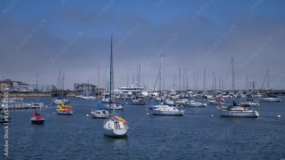 Slow motion landscape of yachts sail boats docked in marine port harbour near boardwalk coastline beach sea ocean of Monterey California USA America holiday travel Slow motion landscape of yachts sail boats docked in marine port harbour near boardwalk coastline beach sea ocean of Monterey California USA America holiday travel