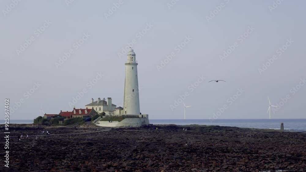 Old Lighthouse On The Seashore With Distant Wind Turbines In The Evening Old Lighthouse On The Seashore With Distant Wind Turbines In The Evening