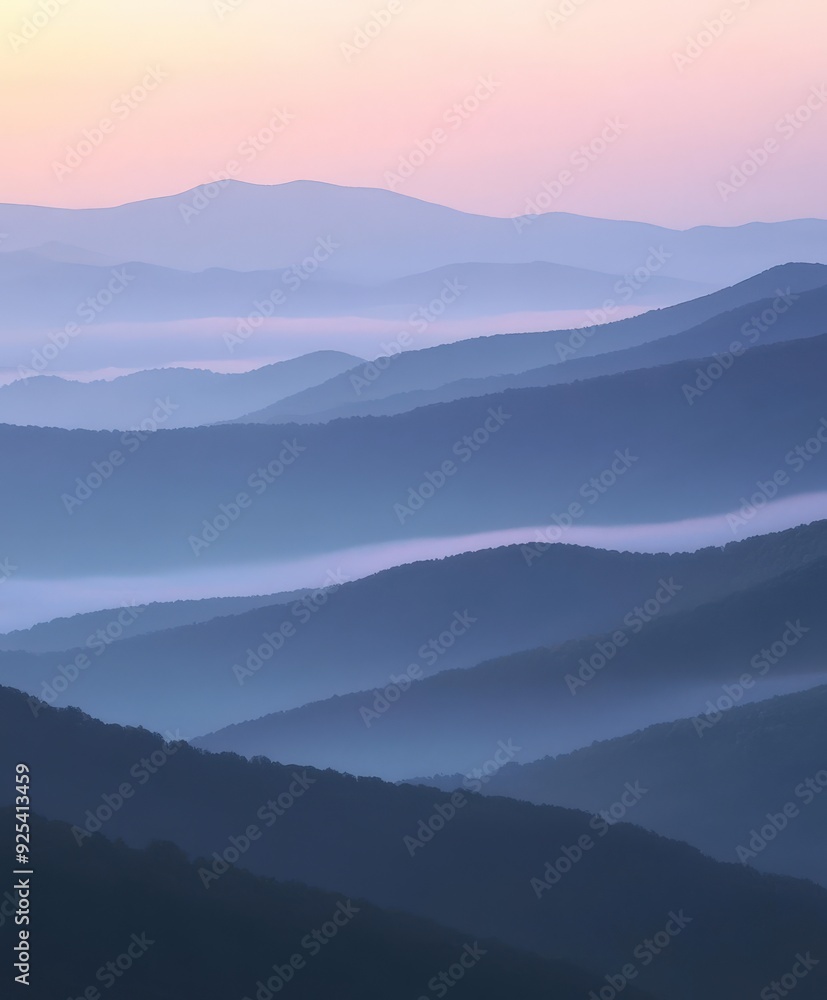 Fototapeta premium Evening fog envelops rolling mountains at twilight
