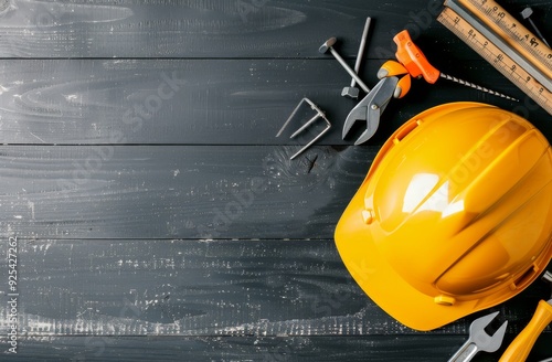 Construction Tools and Safety Helmet on Dark Wooden Surface in Workshop Setting