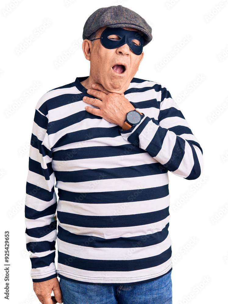 Senior handsome man wearing burglar mask and t-shirt touching painful neck, sore throat for flu, clod and infection Senior handsome man wearing burglar mask and t-shirt touching painful neck, sore throat for flu, clod and infection